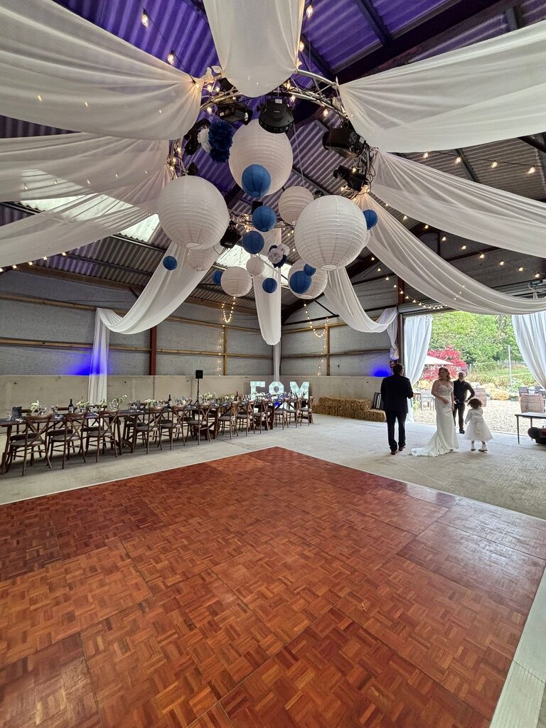 Wide view of the barn with tables and dance floor