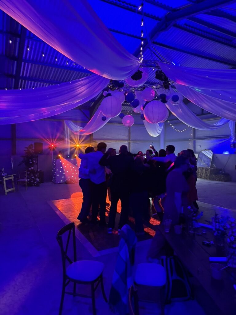 Guests dancing beneath draped fabric in the barn