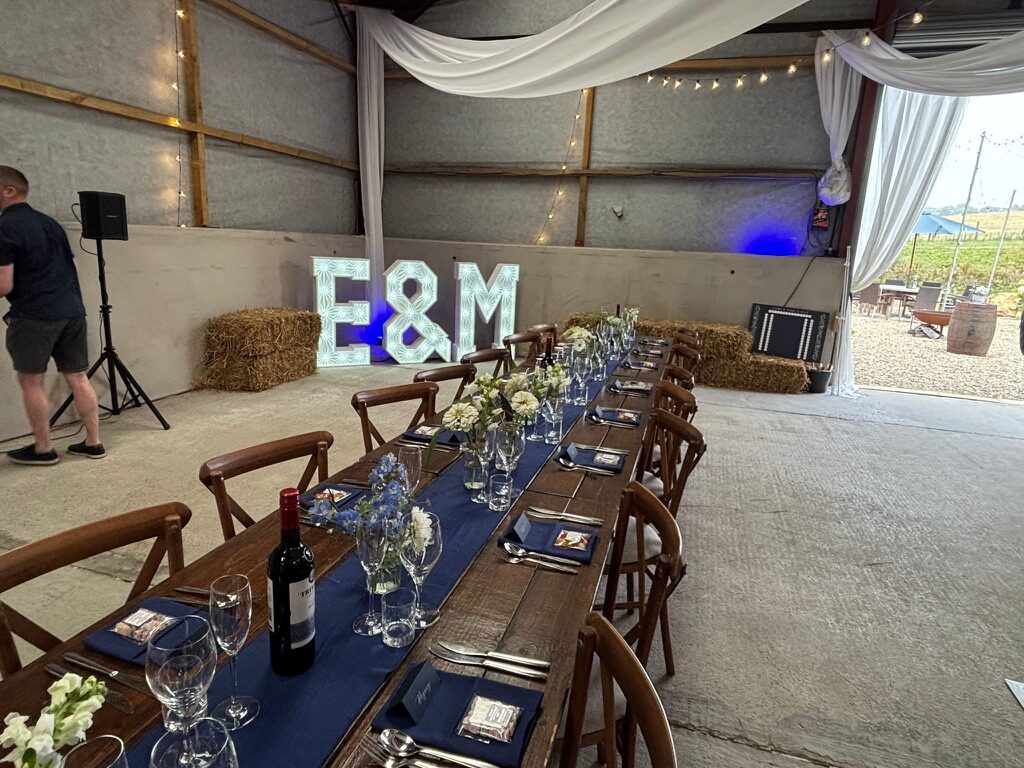 Long wedding table set inside the Hewletts Farm barn
